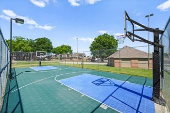A basketball court with a blue and green surface and a basketball hoop.